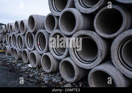 Gros tas de tuyaux de drainage en béton sur un chantier de construction Banque D'Images