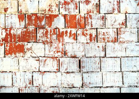 Vieux mur fait de blocs thermiques d'argile peints en couleur blanche qui se décolle de la surface comme arrière-plan Banque D'Images