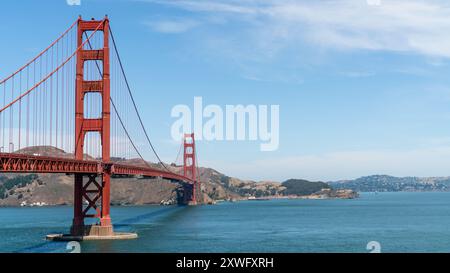 Le Golden Gate Bridge s'étend sur la baie de San Francisco par une journée d'été ensoleillée, mettant en valeur sa teinte rouge vibrante et son design architectural époustouflant. Banque D'Images