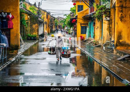 Hoi an, Vietnam, 21 novembre 2022 : scène de rue dans la vieille ville de Hoi an, Vietnam par un jour de pluie Banque D'Images