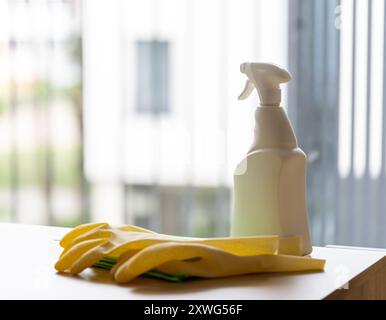 agent nettoyant en flacon pulvérisateur blanc sur table, concept de nettoyage de maison contre fenêtre propre Banque D'Images