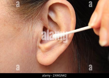 Soin des oreilles avec un coton-tige Banque D'Images