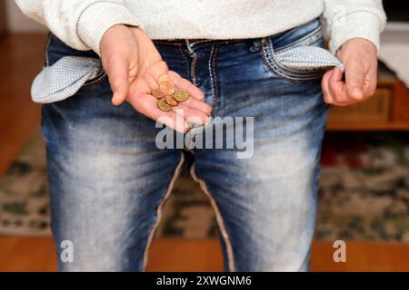 Femme avec des poches de pantalon vides et peu de changement dans la main, pauvreté en Allemagne, Allemagne Banque D'Images