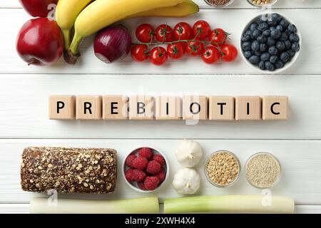 Mot prébiotique fait de cubes et de différents produits sur table en bois blanc, pose à plat Banque D'Images