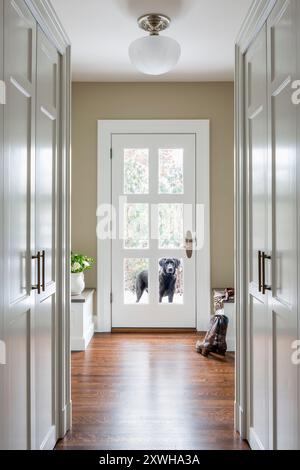 Entrée et mudroom de la maison montrant l'espace de stockage avec le chien dans l'entrée de la porte Banque D'Images