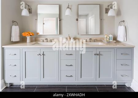 Belle vanité double lavabo dans la salle de bains grise avec miroirs pivotants Banque D'Images