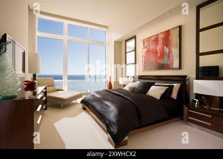 Chambre moderne avec vue sur le lac supérieur et lit avec draps en satin noir Banque D'Images