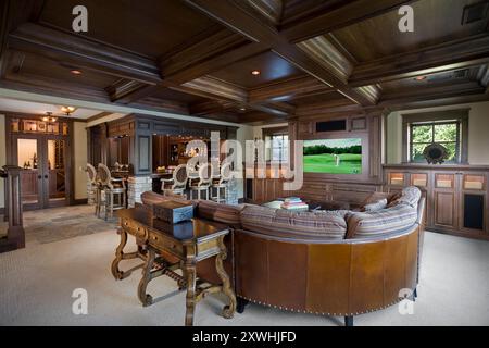 Chambre familiale chaleureuse avec beaucoup de bois sombre intégrés, salle à vin et bar Banque D'Images