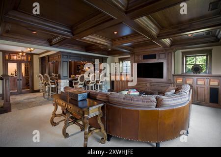 Chambre familiale chaleureuse avec beaucoup de bois sombre intégrés, salle à vin et bar Banque D'Images