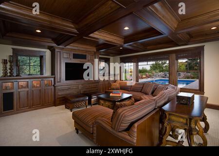 Chambre familiale chaleureuse avec beaucoup de bois sombre et vue sur la piscine Banque D'Images