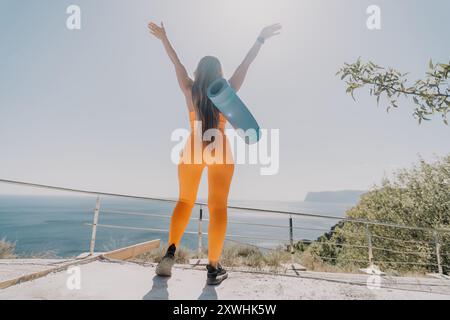 Femme en tenue orange avec tapis de yoga, vue arrière Banque D'Images
