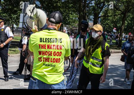 Chiago, États-Unis. 19 août 2024. Un contre-manifestant chahute des activistes lors de la “Marche sur le DNC” à Chicago, il le lundi 19 août 2024. Des milliers de manifestants ont défilé près de la Convention nationale démocrate à la guerre d'Israël à Gaza et au soutien des États-Unis à Israël. Crédit : Sipa USA/Alamy Live News Banque D'Images