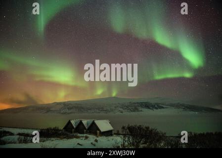 Aurores boréales au-dessus des cabanes près de Olderfjord, sur le chemin de Nordkapp (Cap Nord) (Finnmark, Norvège) ESP : auroras boreales sobre unas Cabañas Banque D'Images