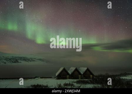 Aurores boréales au-dessus des cabanes près de Olderfjord, sur le chemin de Nordkapp (Cap Nord) (Finnmark, Norvège) ESP : auroras boreales sobre unas Cabañas Banque D'Images