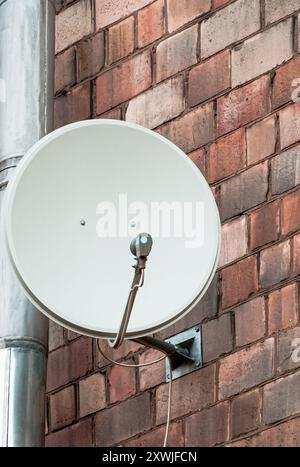 antenne parabolique de communication par satellite sur mur de briques Banque D'Images