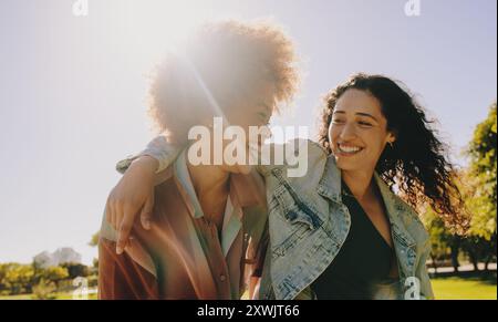 Deux meilleurs amis riant et profitant de la compagnie de l'autre un jour d'été dans le parc. Bonheur et amitié dans un cadre naturel en plein air. Banque D'Images