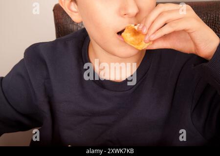 Un homme caucasien mange un hamburger frais au sésame à moitié mangé, culture de restauration rapide américaine Banque D'Images