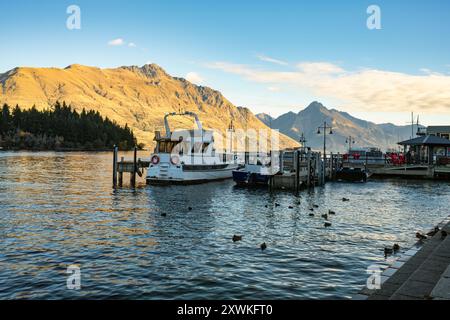 Vue panoramique du front de mer de Queenstown avec bateau à l'embarcadère et montagne sur le lac Wakatipi en automne à l'île du Sud de la Nouvelle-Zélande Banque D'Images