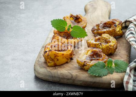 Dessert délicieux et sain de coing cuit au four avec du miel et des épices sur fond gris Banque D'Images