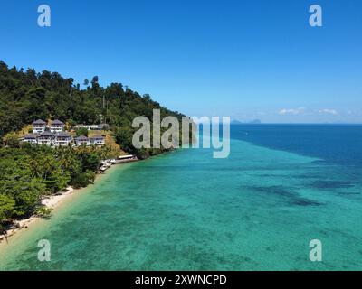 Vue aérienne de la plage de Ko Ngai avec l'eau turquoise intense le matin d'une journée d'été ensoleillée, et stations balnéaires avec bungalows près de la mer Banque D'Images