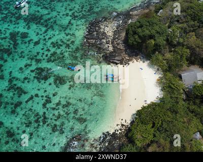 Vue aérienne de la plage Viking sur Koh Phi Phi Don à Krabi, avec des eaux turquoises et des bateaux à longue queue près du sable blanc entouré de récifs coralliens Banque D'Images