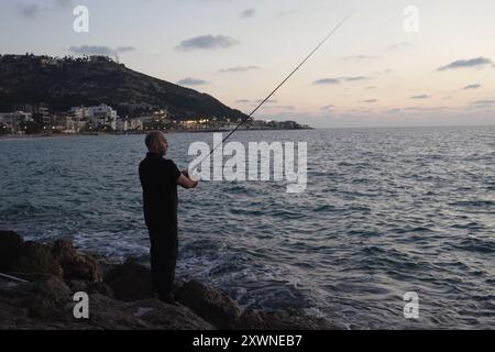 Une personne pêche à la plage de Bat Galim le 14 août 2024 à Haïfa, en Israël. Banque D'Images