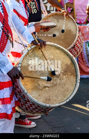 Batteurs avec des tambours en bois rustiques et colorés lors d'un événement culturel afro-brésilien dans les rues du Brésil Banque D'Images