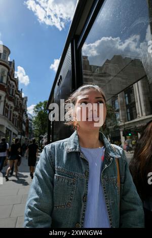 Londres - 06 12 2022 : gros plan d'une fille sérieuse marchant dans Oxford St Banque D'Images