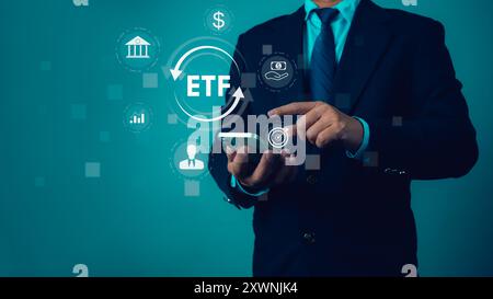 Man utilise smartphone pour analyser et gérer le compte ETF en ligne. Représente la croissance des investissements et affiche les icônes du marché boursier des fonds négociés ETF Exchange Banque D'Images