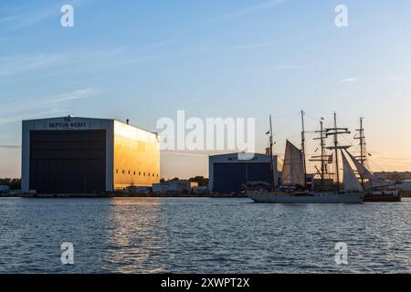 Segelschiff fährt an der Neptun Werft während der Hansesail 2024 vorbei, 10.08.2024, Werfthalle am Abend Neptunwerft à Rostock-Warnemünde *** voilier passe devant le chantier naval de Neptun pendant le Hansesail 2024, 10 08 2024, hall du chantier naval dans la soirée chantier naval de Neptun à Rostock Warnemünde 20240810-DSC 4136 Banque D'Images