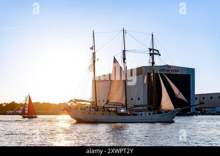 Segelschiff fährt an der Neptun Werft während der Hansesail 2024 vorbei, 10.08.2024, Werfthalle am Abend Neptunwerft à Rostock-Warnemünde *** voilier passe devant le chantier naval de Neptun pendant le Hansesail 2024, 10 08 2024, hall du chantier naval dans la soirée chantier naval de Neptun à Rostock Warnemünde 20240810-DSC 4132 Banque D'Images