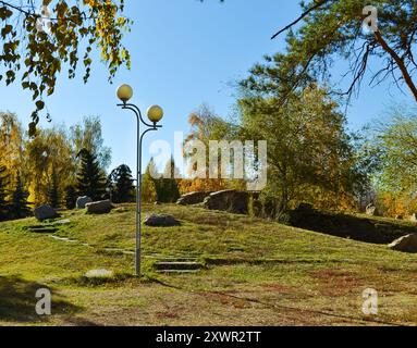 Un lampadaire se dresse sur une colline dans un parc d'automne par une journée ensoleillée Banque D'Images