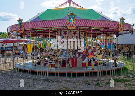 Joyeux vintage lumineux et coloré faire le tour du carnaval à la foire restaurée avec des chevaux en fibre de verre et des animaux avec tente en toile sur une journée ensoleillée dans s. Banque D'Images