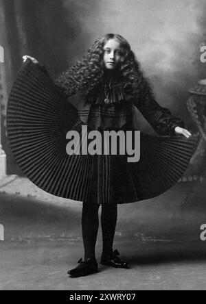 Une adolescente pose dans une robe plissée incroyablement belle, vers 1910. Banque D'Images