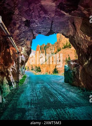 Tunnel surréaliste montrant des falaises déchiquetées avec des tons bleu jaune et bleu ciel. Old Road ouvre une fois par an au Buffalo Bill Dam Park, Cody WY. Banque D'Images