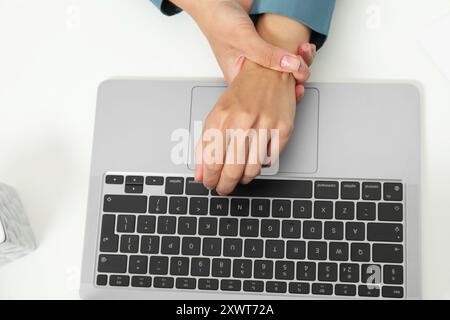 Syndrome du canal carpien. Femme souffrant de douleur au poignet au bureau, vue de dessus Banque D'Images