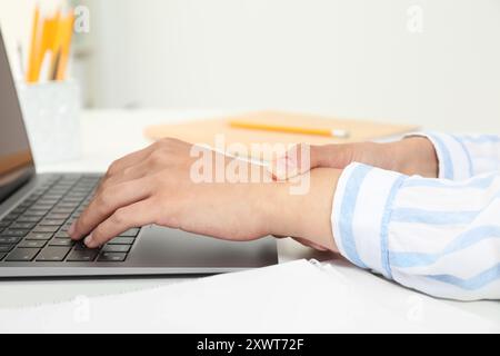 Syndrome du canal carpien. Femme souffrant de douleur au poignet au bureau, gros plan Banque D'Images