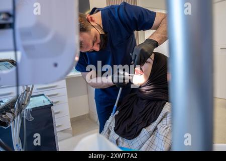 une femme musulmane sur un fauteuil dentiste a besoin d'un traitement pour son mal de dents Banque D'Images