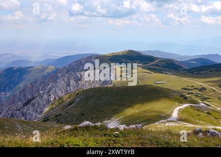 Une vue imprenable depuis le sommet de Schneeberg surplombant le vaste plateau de Schneeberg en Autriche. Les collines verdoyantes sont parsemées de roches Banque D'Images