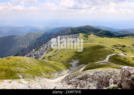 Une vue imprenable depuis le sommet de Schneeberg surplombant le vaste plateau de Schneeberg en Autriche. Les collines verdoyantes sont parsemées de roches Banque D'Images