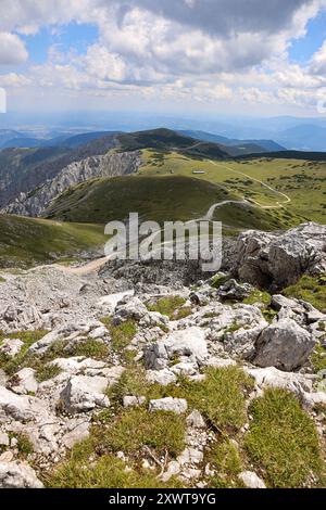 Une vue imprenable depuis le sommet de Schneeberg surplombant le vaste plateau de Schneeberg en Autriche. Les collines verdoyantes sont parsemées de roches Banque D'Images