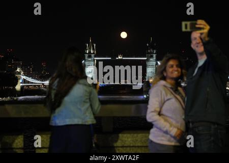 Une lune gibbbeuse décroissante se lève au-dessus de Tower Bridge à Londres. Date de la photo : mardi 20 août 2024. Banque D'Images