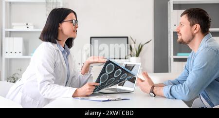 Femme médecin avec IRM parlant au patient en clinique Banque D'Images