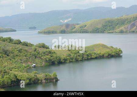 Blick auf den Sentani Voir. Zahlreiche Berge und Erhebungen wurden abgeholzt. Der Sentani See ist das größte Binnensee in West-Papua und ist sehr unregelmäßig geformt. In der Umgebung des Sees leben etwa 30,000 Menschen der Volksgruppe der Sentani in 30 Dörfern, die sich von Fischen des Sees, Tieren, Früchten und Gemüse der Umwelt ernähren. Der See entstand möglicherweise durch eine tektonische Anhebung, belegt ist dies allerdings nicht. IM Norden befindet sich bergiges Gelände, im Süden wird es flacher. DAS Einzugsgebiet beträgt etwa 600 Quadratkilomètre mit mittleren Jahresniederschlägen von Banque D'Images