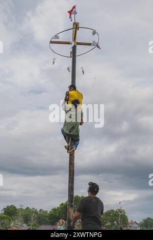 Balikpapan, Indonésie - 18 août 2024.le joueur doit attraper le drapeau avant de réclamer les prix dans le Panjat Pinang ou grimper au palmier est une pop Banque D'Images