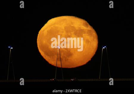 Lisbonne, Portugal. 20 août 2024. La pleine lune se lève de la structure du pont Vasco da Gama à Lisbonne. La Lune bleue, nommée d'après la deuxième pleine lune au cours du même mois du calendrier grégorien, est la première de 2024 et a la particularité d'orbiter près de 22 mille kilomètres plus près de la Terre. (Photo de Jorge Castellanos/SOPA images/SIPA USA) crédit : SIPA USA/Alamy Live News Banque D'Images