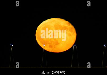 Lisbonne, Portugal. 20 août 2024. La pleine lune se lève de la structure du pont Vasco da Gama à Lisbonne. La Lune bleue, nommée d'après la deuxième pleine lune au cours du même mois du calendrier grégorien, est la première de 2024 et a la particularité d'orbiter près de 22 mille kilomètres plus près de la Terre. (Photo de Jorge Castellanos/SOPA images/SIPA USA) crédit : SIPA USA/Alamy Live News Banque D'Images