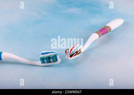 Brosse à dents avec dentifrice sur fond bleu. Dentifrice extrudé du tube sur la brosse à dents gros plan. Banque D'Images