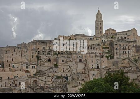 La section “Sassi” de Matera - située dans le sud de l'Italie - est représentée dans une vue large pendant une journée nuageuse. Les habitations de grotte de falaise de cet ancien Banque D'Images