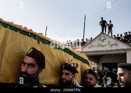 Majdal Slim, Liban. 20 août 2024. Les personnes en deuil portent le cercueil du combattant du Hezbollah Abbas Badii Milhim, né en 1990 avec l'indicatif d'appel "Jihad" qui a été tué par les forces israéliennes dans le sud du Liban lors de sa cérémonie funéraire. Crédit : SOPA images Limited/Alamy Live News Banque D'Images